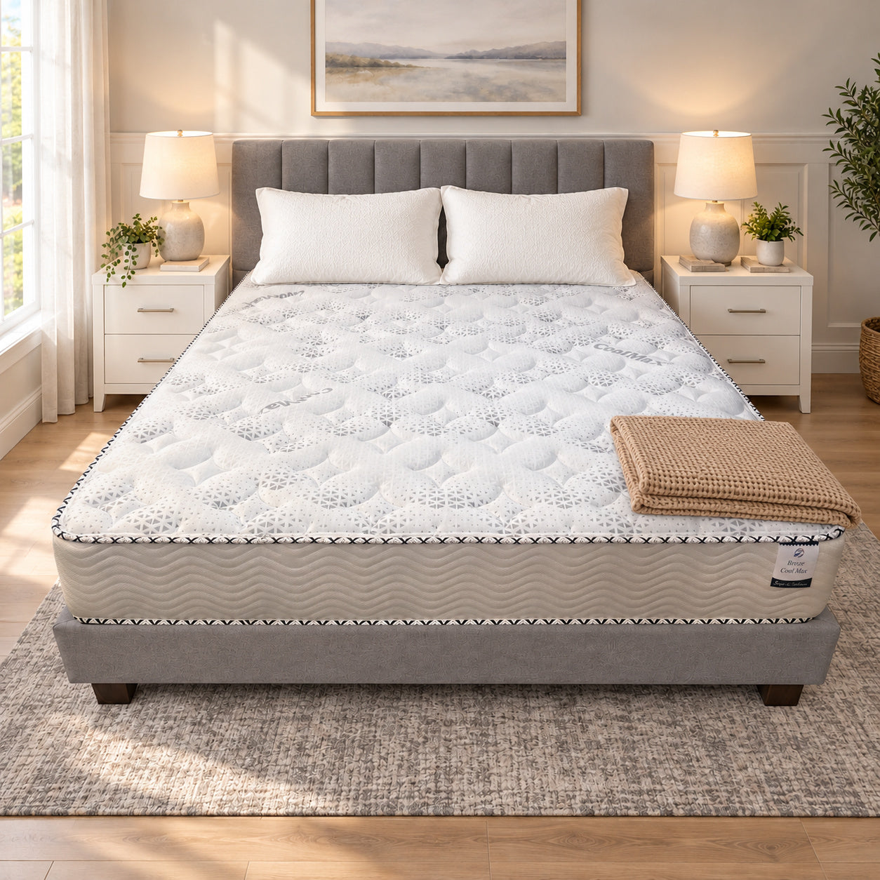California King Breeze Cool Max 10" Medium Firm Tight top mattress on a gray upholstered bed with two white pillows and a tan knit throw, in a bedroom with white nightstands, table lamps and a framed landscape print